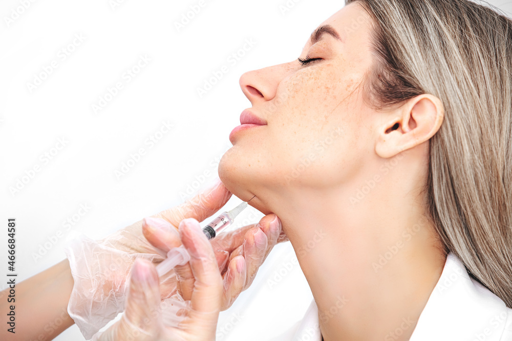 Skin lifting injection. Woman receiving beauty injection over white background. Studio shot. Skin lifting injection. Woman receiving beauty injection over white background. Studio shot.