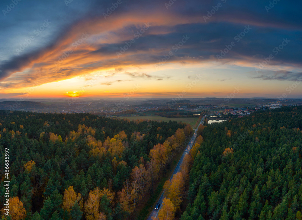 Beautiful sunset over the autumnal forest in Rotmanka, Poland