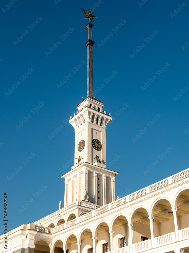 Northern River Station. Spire with a star on the roof of the building against the blue sky. Close-up, vertical.