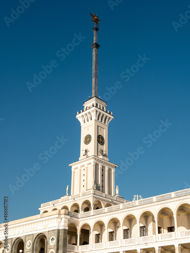 Northern River Station. Spire with a star on the roof of the building against the blue sky. Side view. Close-up, vertical.