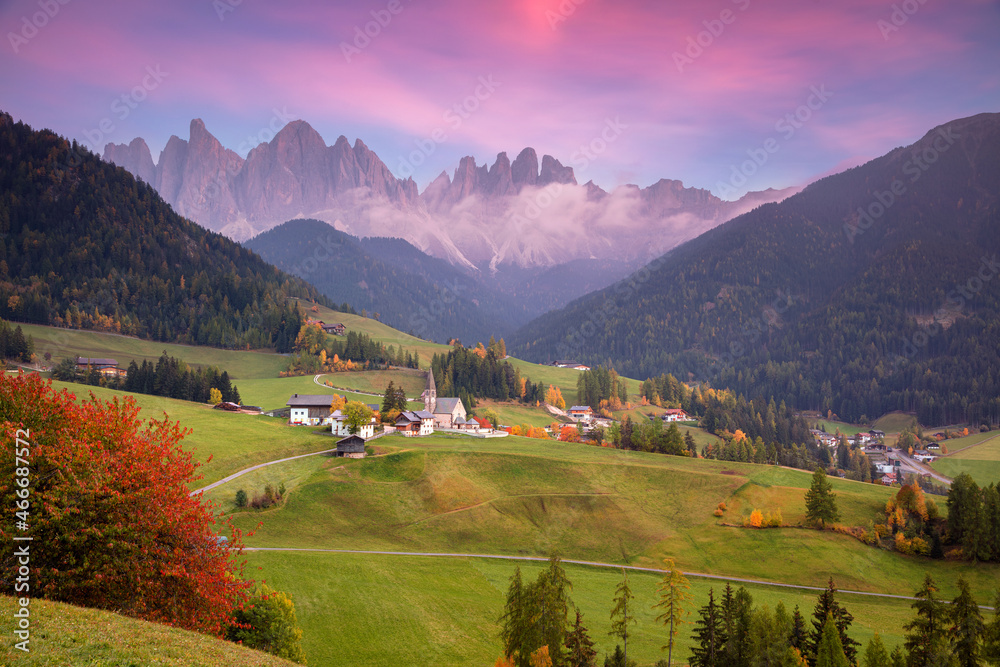 Autumn in Alps. Beautiful St. Magdalena village with magical Dolomites mountains in a gorgeous Val di Funes valley,  South Tyrol, Italian Alps at autumn sunset.