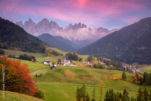 Autumn in Alps. Beautiful St. Magdalena village with magical Dolomites mountains in a gorgeous Val di Funes valley, South Tyrol, Italian Alps at autumn sunset.