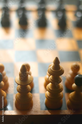 Wooden chessboard and vintage carved figurines. Selective focus.