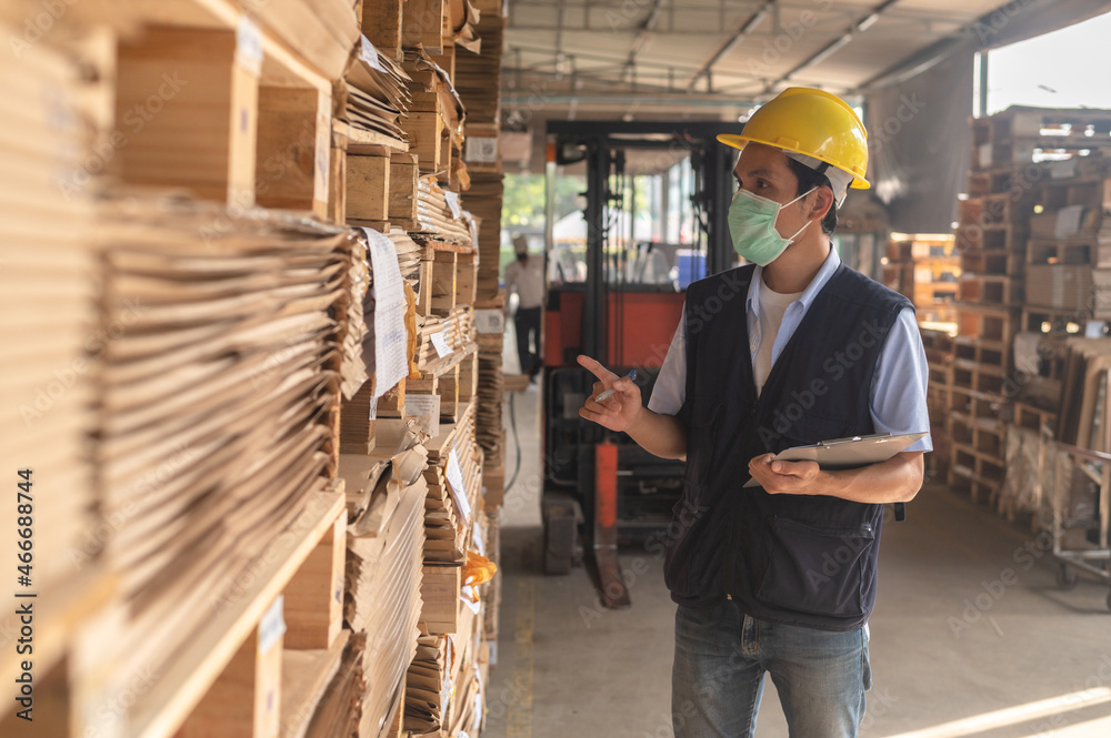 Worker checking raw material inventory in factory Worker checking raw material inventory in factory