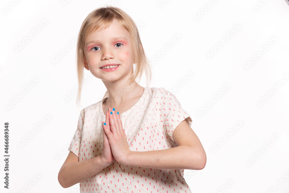 Little European girl in white clothes hold hands like as praying with happy facial expression. Blond little girl praying peacefully isolated, close up space for text Little European girl in white clothes hold hands like as praying with happy facial expression. Blond little girl praying peacefully isolated, close up space for text