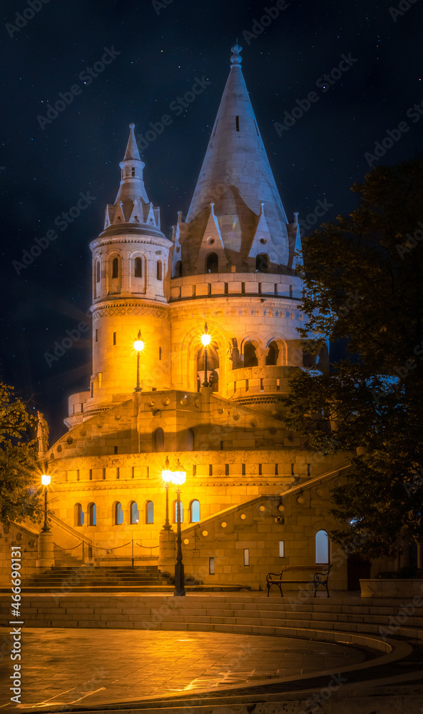 The Fisherman's Bastion in floodlight under the starry night sky in Hungary, Budapest