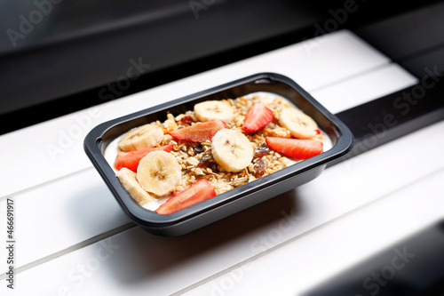 Porridge with fruits and nuts. A healthy nutritious breakfast in a box.
Appetizing ready-to-go dish served in a disposable box. Culinary photography.