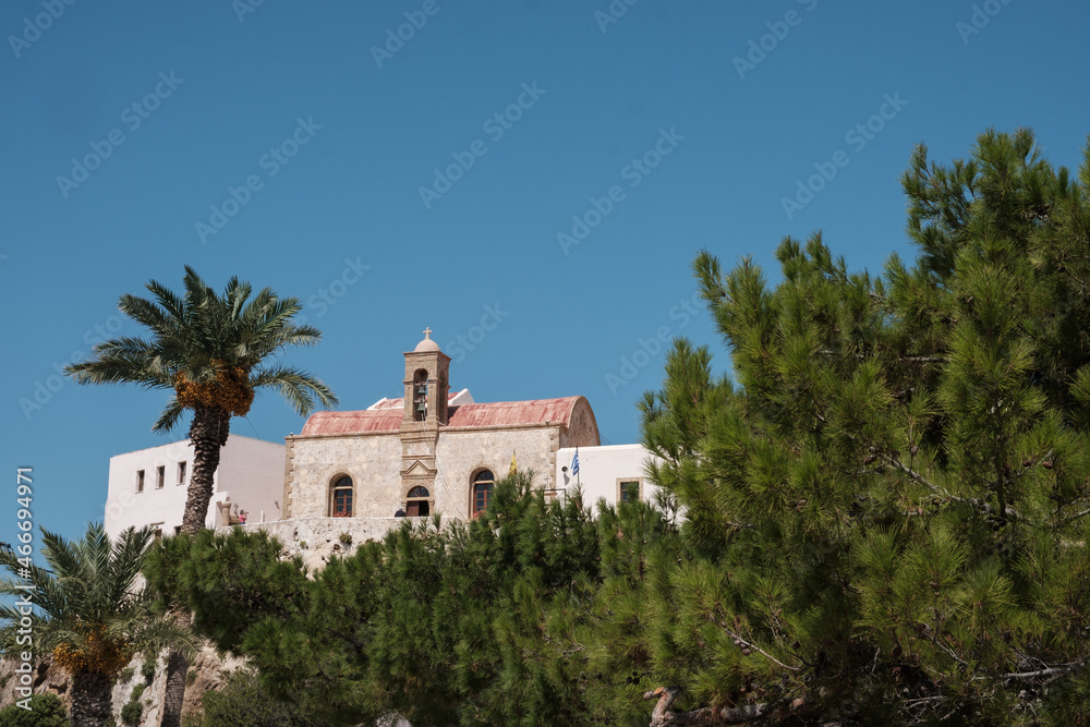 View on Chrisoskalitissa monastery through the trees and behind clear sky