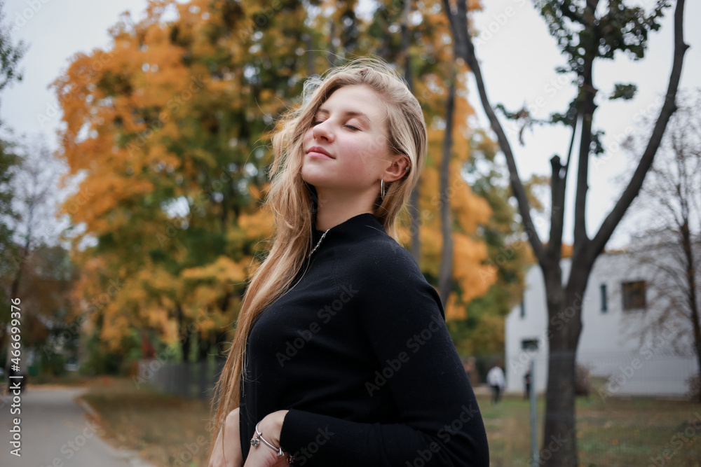 Girl in a black sweater and chain closes her eyes Girl in a black sweater and chain closes her eyes