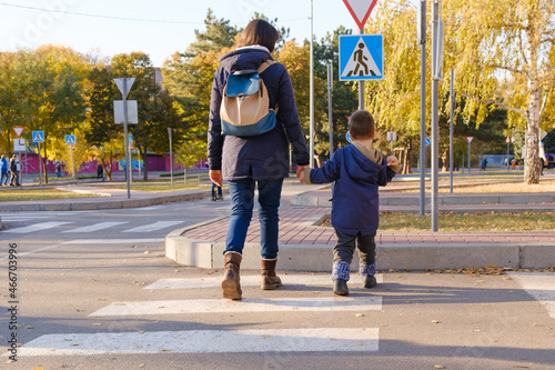 Φωτογραφία Mom and child cross the road at the zebra crossing.