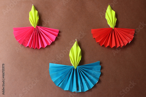 Diwali lamp made with origami paper on brown background