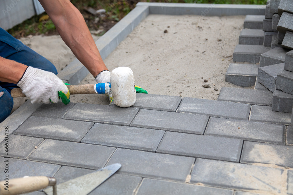 A worker lays paving slabs A worker lays paving slabs