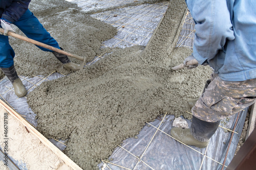 Workers level out the concrete mix at a construction site.