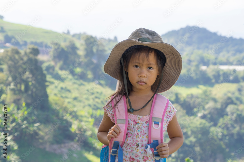 Little asian kids hiking mountain. Child mountaineer having fun while climbing a mountain with a backpack.