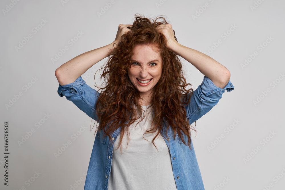 Fototapeta premium Redhead woman with hands in hair