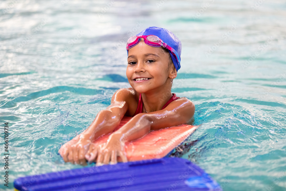 Portrait of little smiling girl in swimming pool