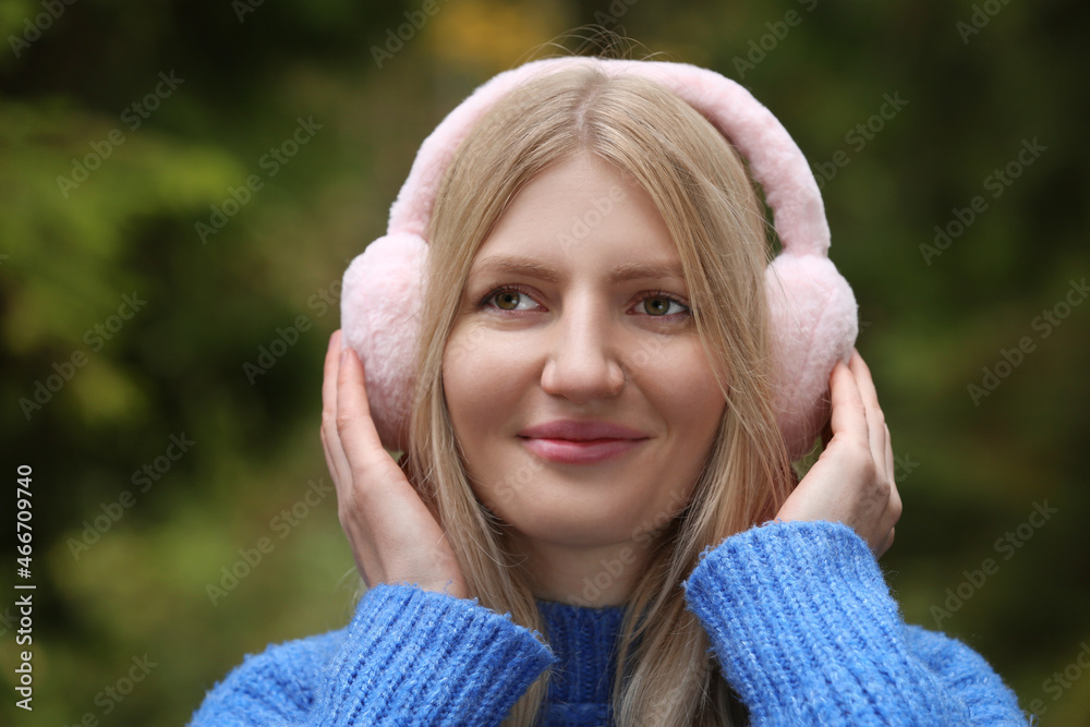 Young beautiful woman wearing warm earmuffs outdoors Young beautiful woman wearing warm earmuffs outdoors