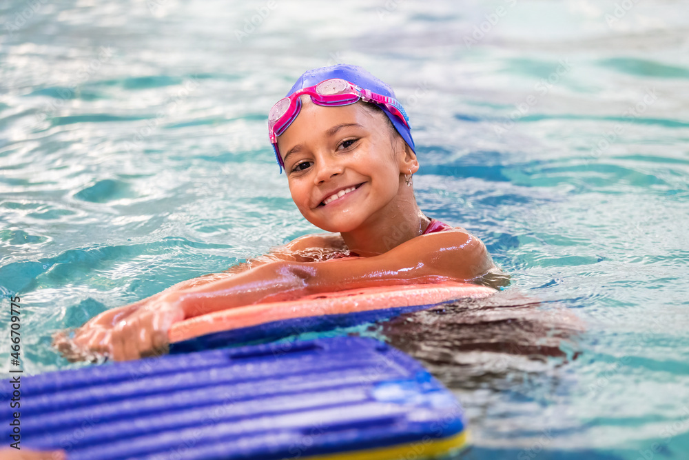 Portrait of little smiling girl in swimming pool