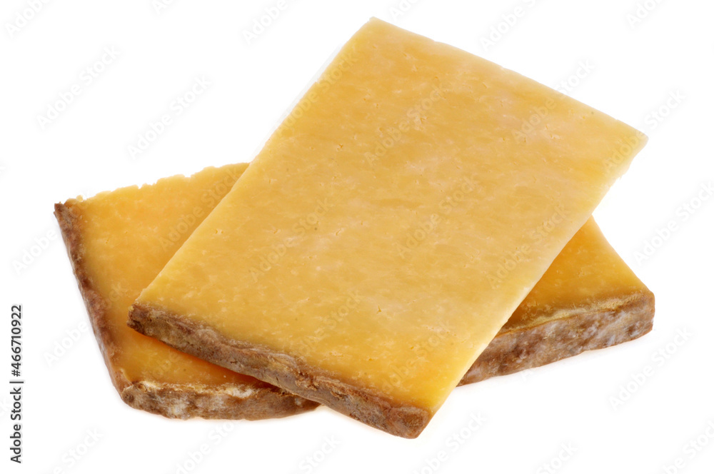 Morceaux de fromage de Cantal en gros plan sur fond blanc Morceaux de fromage de Cantal en gros plan sur fond blanc