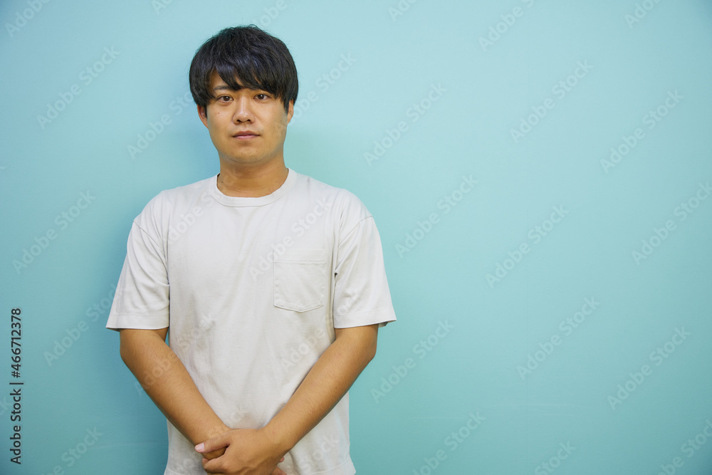 青背景の前で爽やかに笑う日本人男性 青背景の前で爽やかに笑う日本人男性