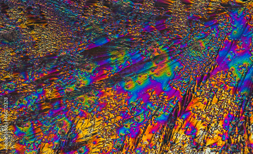 Extreme macro photograph of Vitamin C crystals forming abstract modern art patterns, when illuminated with polarized light, under a microscope objective with 10x magnification © lukjonis