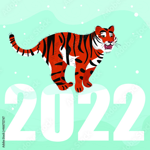 The tiger, the symbol of the new year, stands on the numbers 2022, which symbolizes the coming new year. Snow is falling behind him. © Kseniya