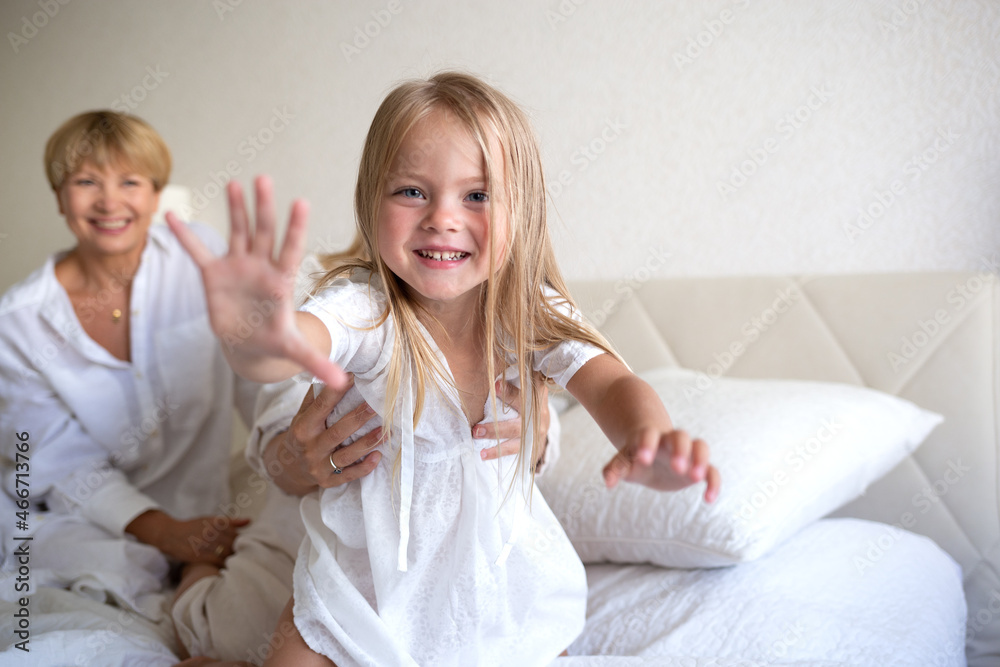 family portrait: mom, daughter and granddaughter are sitting on the bed family portrait: mom, daughter and granddaughter are sitting on the bed