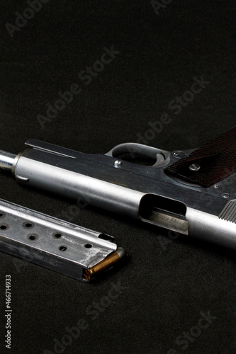 Automatic white gun stainless steel pistol weapon model m1911 with real bullet ammo head in black background