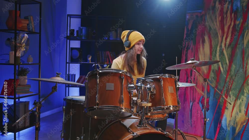 Waist up portrait view of the female drummer wearing casual clothes sitting at the drum cymbal and preparing to the concert during the repetition