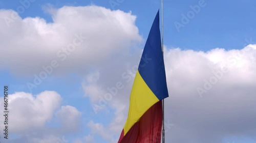 Big Romania Flag on post moving in the wind. Romanian red, yellow and blue flag waving in the wind.
