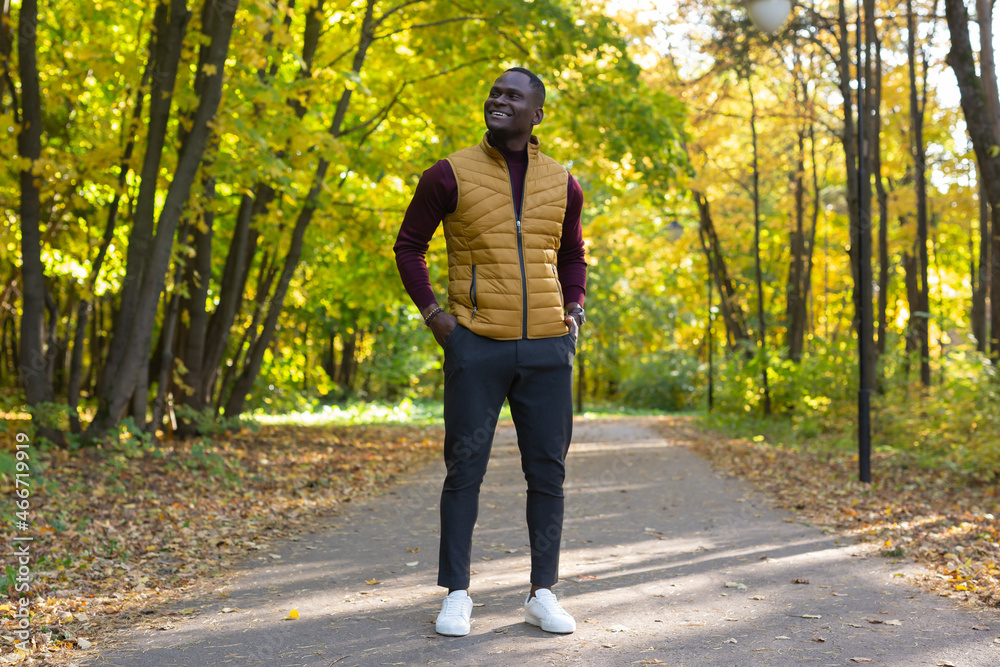 Hipster african american man walking in autumn park Hipster african american man walking in autumn park