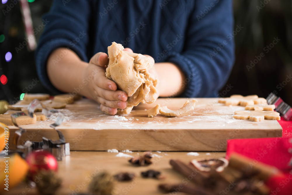 Child rolling out dough for christmas cookies