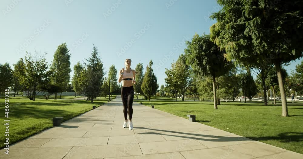 Active fitness woman runner jogging in sunny street summer day outdoors.