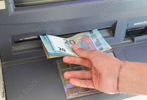 man taking banknotes from cash machine euro cash machine in European city