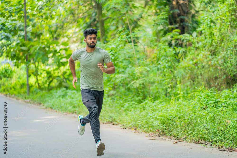 Young man running in the park at morning, also known as jogging or morning walk Young man running in the park at morning, also known as jogging or morning walk