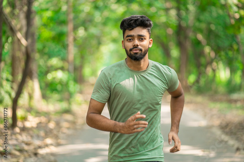 Young man running in the park at morning, also known as jogging or morning walk