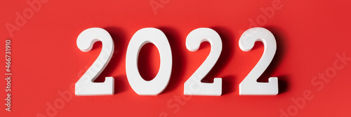 Happy New Year. White wooden numbers 2022 isolated on red background . Greeting card. Banner. Top view, flat lay.