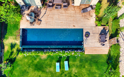 Swimming Pool viewed from above. Top down view of modern luxury villa with swimming pool. Aerial luxury resort landscape, resort hotel swimming pool, vacation background © Aloshin Evgeniy
