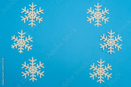 The Christmas composition, group of white shiny snowflakes form a circle on blue background, copy space. Festive, New Year's concept. Minimum style. Top View.