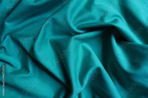 Background - blue green polyester fabric in soft folds