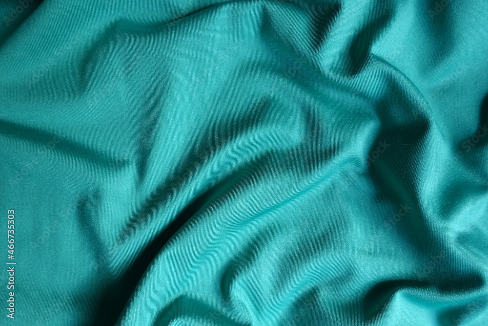 Surface of blue green polyester fabric with soft folds Surface of blue green polyester fabric with soft folds
