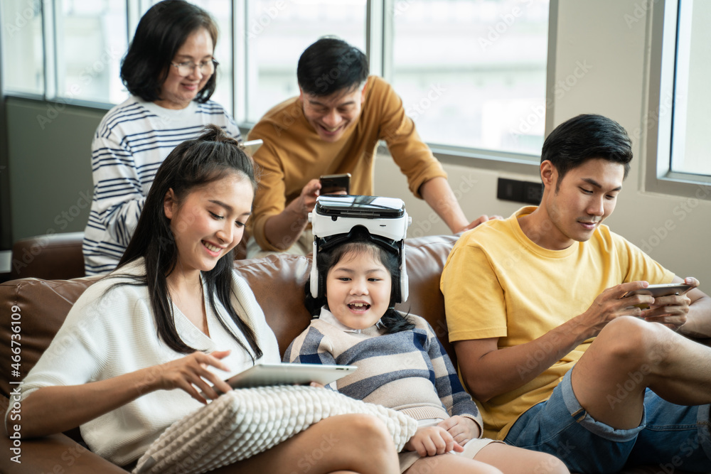 5G Technology for Families concept.Everyone sitting in sofa and using digital devices in living room.Big family grandmother grandfather and kids spending time together at home. 5G Technology for Families concept.Everyone sitting in sofa and using digital devices in living room.Big family grandmother grandfather and kids spending time together at home.