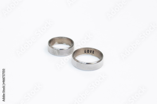 Two silver wedding ring with love writing. White golden wedding rings. Love rings