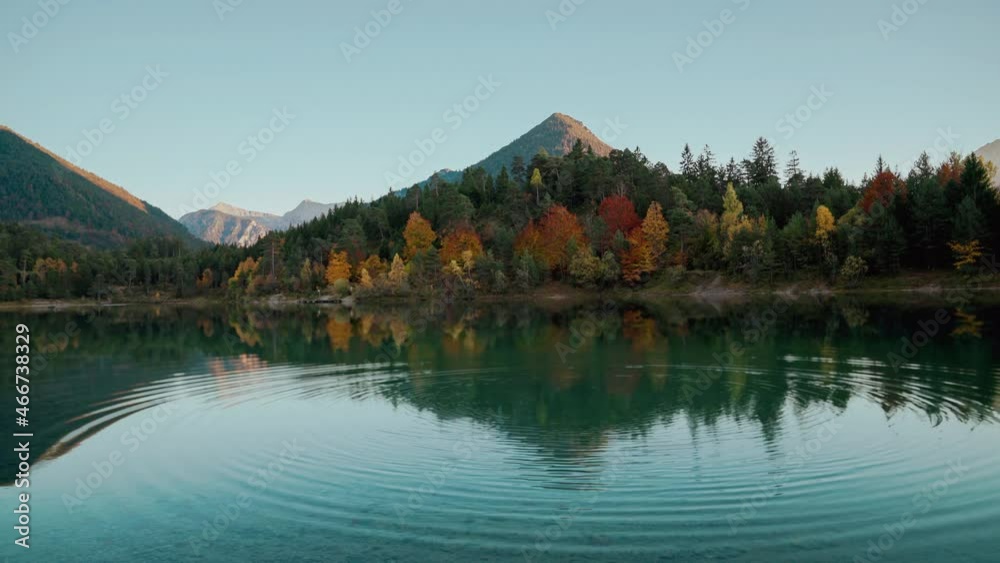 4K UHD Cinemagraph seamless video loop of a mountain lake in the Austrian alps with vibrant autumn leaves and reflection, close to Germany. The water is moving in circular waves, colorful fall trees.
