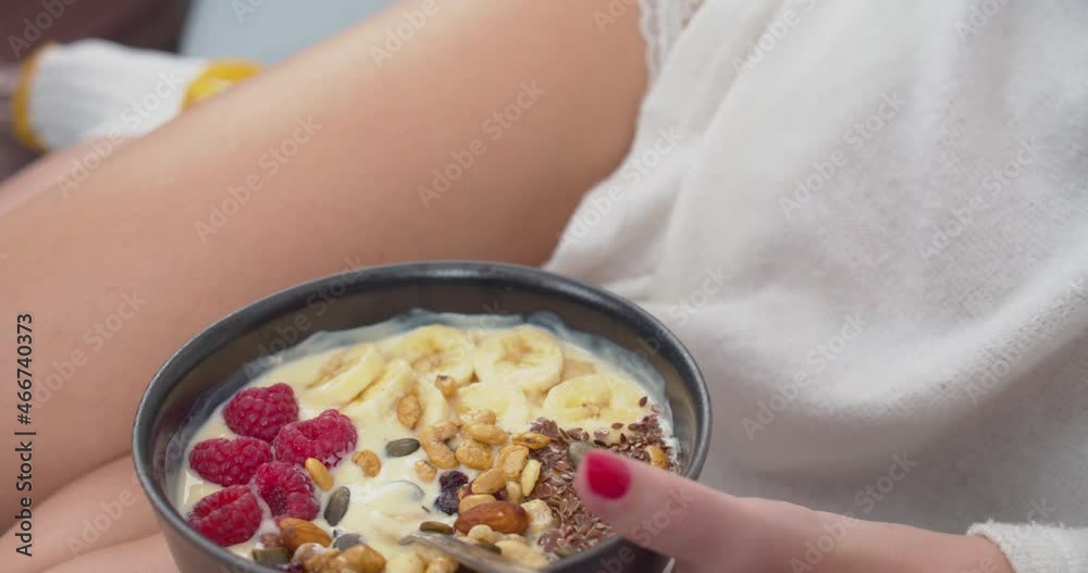 Fit healthy woman eating a bowl with nuts, berries, fruits and yogurt Fit healthy woman eating a bowl with nuts, berries, fruits and yogurt