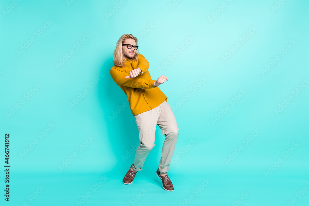Full length photo of young excited guy happy positive smile have fun dance party club isolated over turquoise color background Full length photo of young excited guy happy positive smile have fun dance party club isolated over turquoise color background