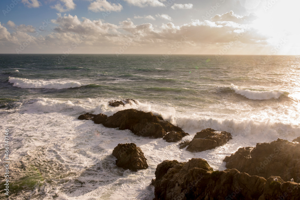 Waves crash along Bodega Bay in northern California at sunset.