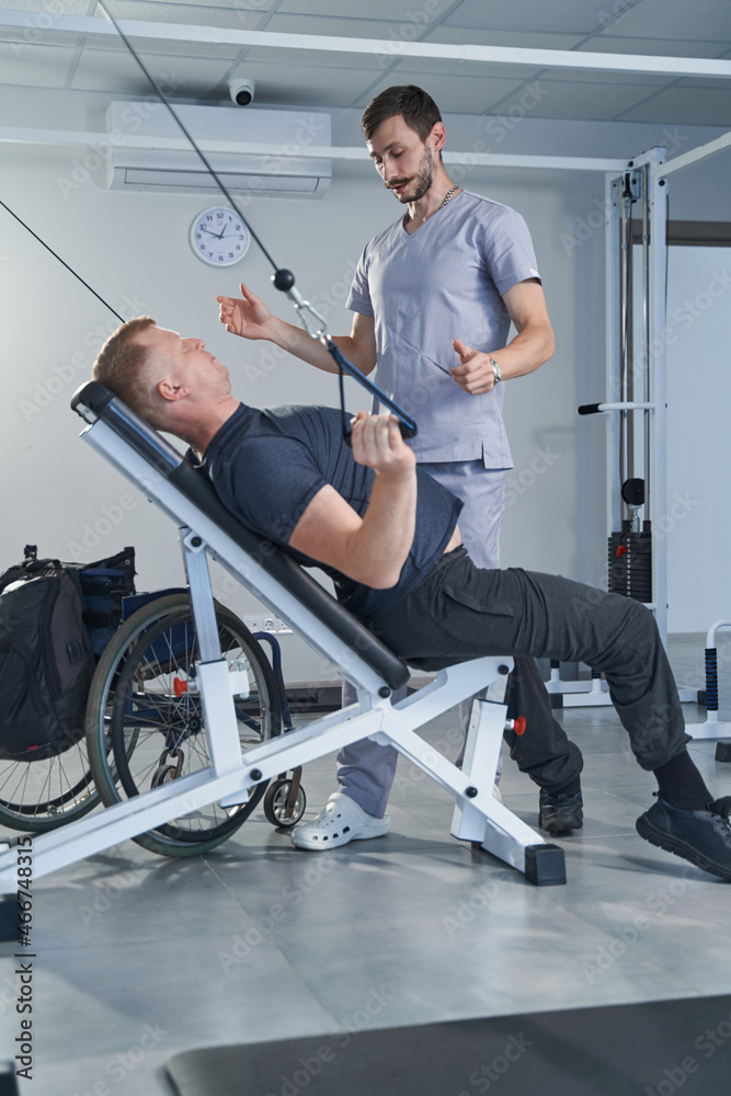 Patient with injury doing strength exercises with physiotherapist help