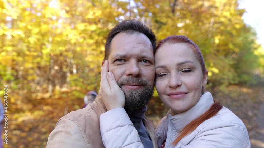 a man and a woman with children take pictures of themselves on camera in the autumn forest, a family on a walk in the park a man and a woman with children take pictures of themselves on camera in the autumn forest, a family on a walk in the park