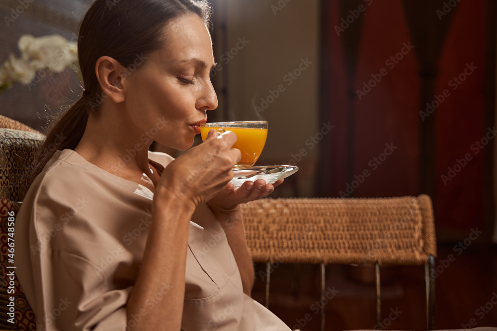 Woman drinking vitamin beverage in wellness center Woman drinking vitamin beverage in wellness center